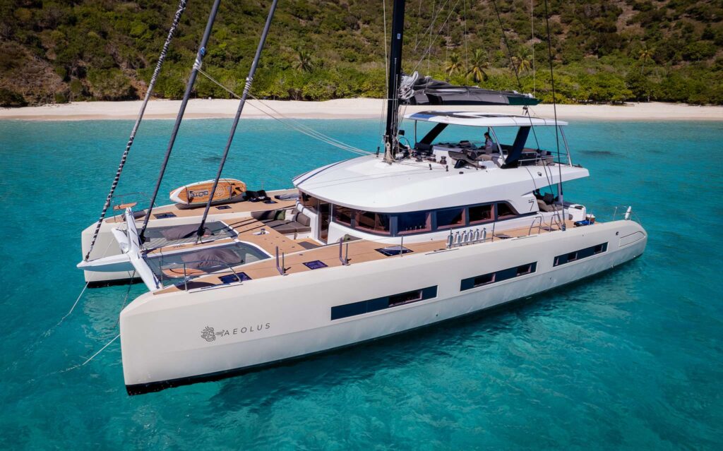 AEOLUS 77, a Lagoon Seventy 7 sailing catamaran, at anchor off a white-sand beach in the BVI