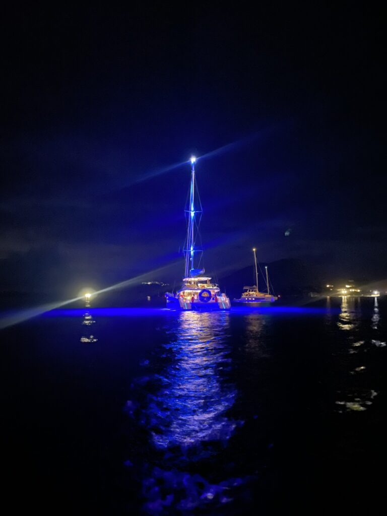 Catamaran INDULGANCE lit up in the evening anchored off CocoMaya, Virgin Gorda BVI