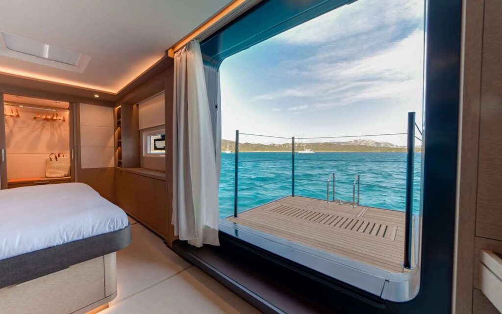 Master cabin on ZENIT, a Lagoon Seventy 8 power catamaran, with the fold-out balcony open over the sea