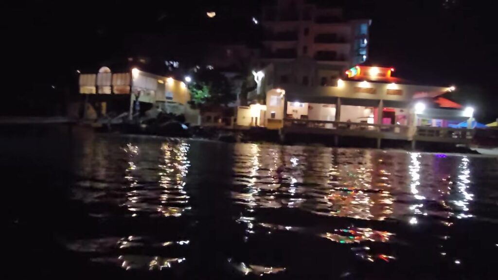 The restaurants along Cane Garden Bay beach lit up at night, seen from the tender, Tortola, November 2025