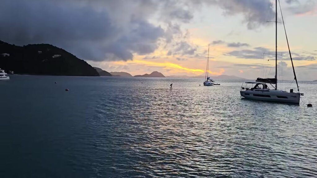 Sunset in Cane Garden Bay, Tortola, with an e-foil crossing the anchorage, November 2025