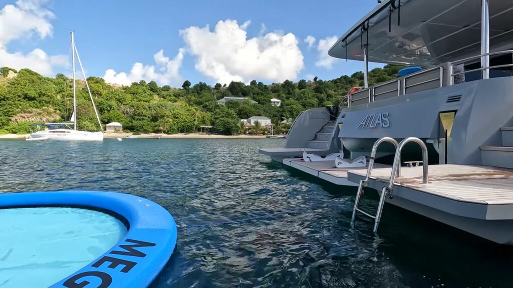 The catamaran ATLAS on the mooring off Cooper Island with the floating pool tied off the stern, November 2025
