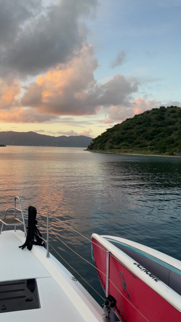 Catamaran bow at sunset, anchored in a calm BVI bay