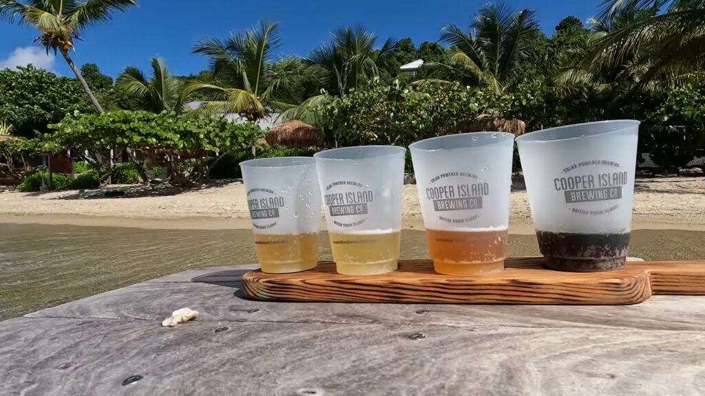 A Cooper Island Brewing Co. beer flight at the water's edge, Manchioneel Bay, November 2025