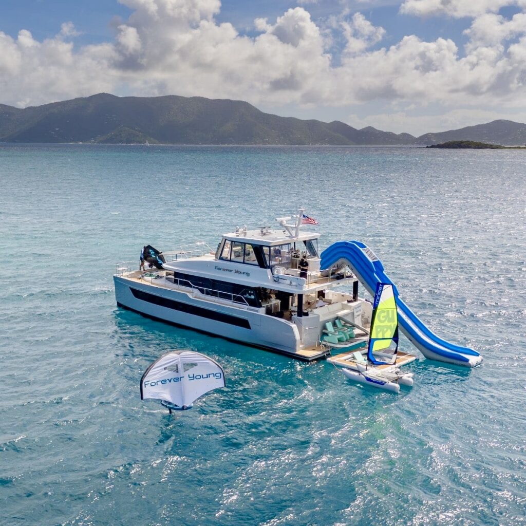Catamaran FOREVER YOUNG at anchor in the BVI with the waterslide and water toys out