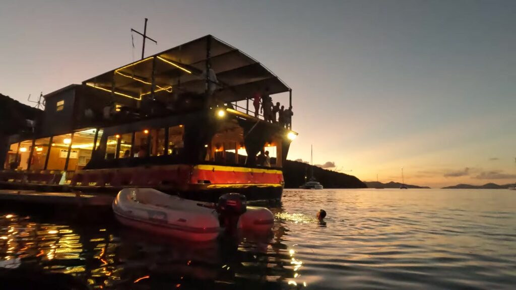 The Willy T at sunset with a swimmer below the jumping deck, the Bight, Norman Island, November 2025