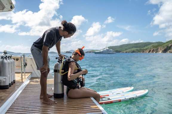Ariel Trasher helping prepare a guest for scuba diving. Access is super easy from the swim ladder off the back.