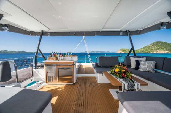 The large flybridge on Luxury Catamaran My Ty, with bar area and lots of seating. What you do not see in this image, is the extensive lie-down sunbathing area which you will also find up here.