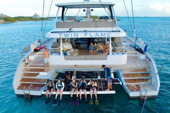 Charter Catamaran 'Twin Flame' guests getting ready for SCUBA diving launching from the hydraulic swim deck