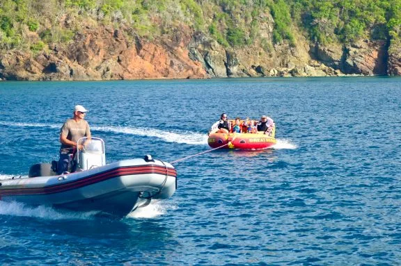 kids being towed behind tender, BVI crewed catamaran TRANQUILITY